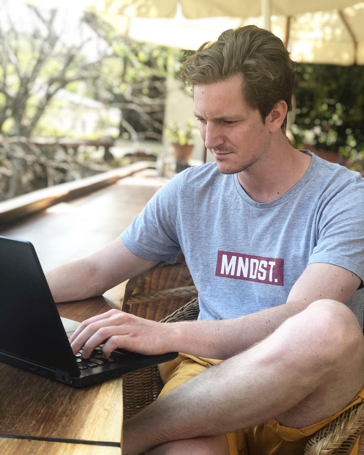 Fritz working on a laptop in an MNDST t-shirt
